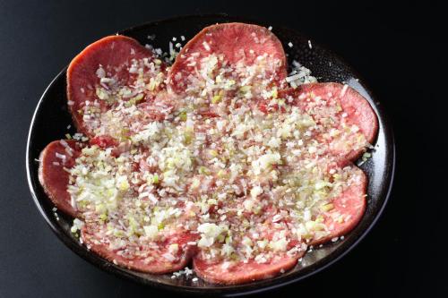 a pizza with meat and cheese in a pan at Hotel Japan Shiga in Yamanouchi