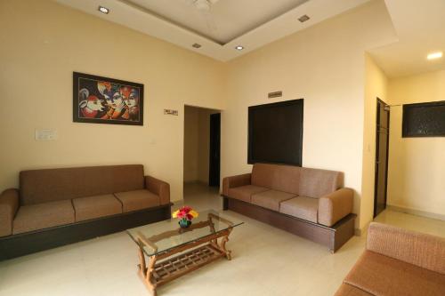a living room with two couches and a flat screen tv at Hotel Kridha Residency - Opposite Prem Mandir Vrindavan in Mathura