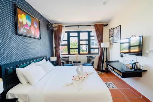a bedroom with a large white bed and a desk at Nova Vista Villa Hoi An in An Bàn (2)