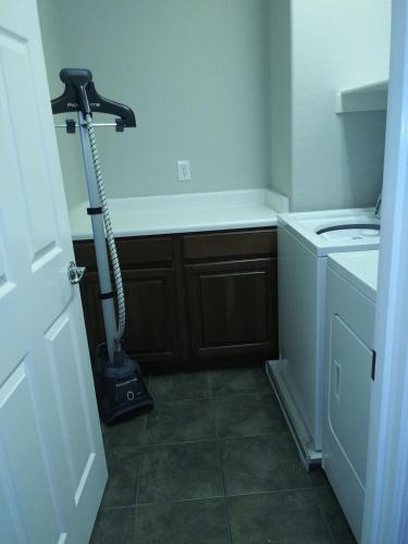 a kitchen with a vacuum in the corner of a room at VILLA Verde Surprise Stadium - Resort Living in Surprise