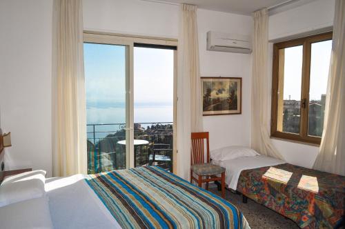a hotel room with two beds and a balcony at Hotel Condor in Taormina