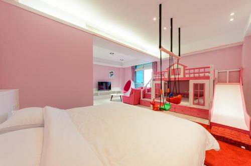 a bedroom with a white bed and a play area at Taiping 528 in Taiping