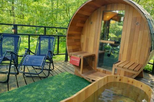 a circular wooden cabin with chairs and a pond on a deck at コーボ in Yamanakako