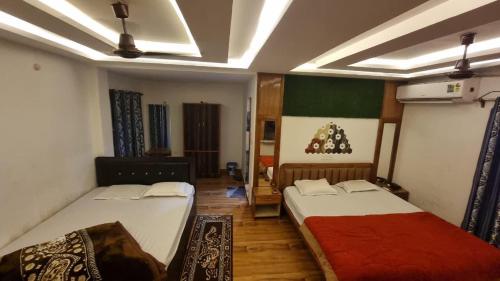 a bedroom with two beds and a christmas tree on the wall at North Queen in Lataguri