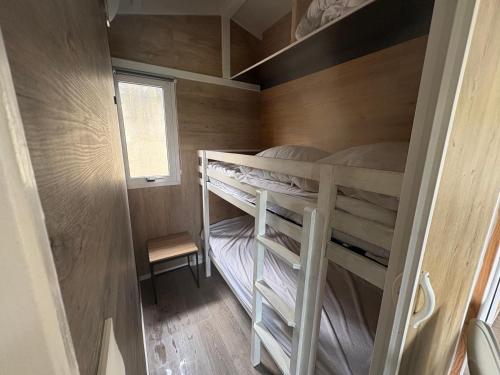 a small bedroom with bunk beds in a tiny house at Petit chalet cosy house in Hermanville-sur-Mer