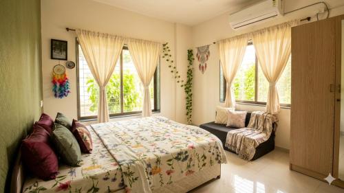a bedroom with a bed and a chair and windows at Pushpchhaya Home Stay in Nashik