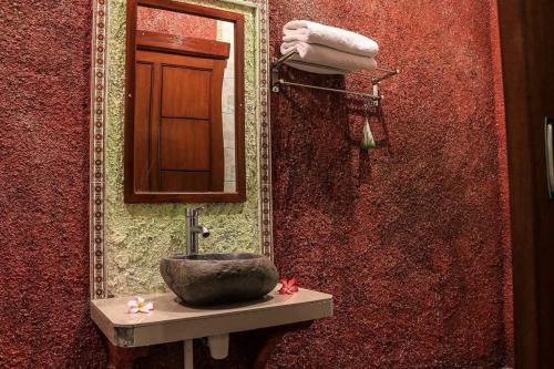 a bathroom with a sink and a mirror at Reynold Artha Guest House in Nusa Lembongan