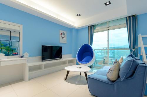 a blue living room with a blue chair and a tv at Taiping 528 in Taiping