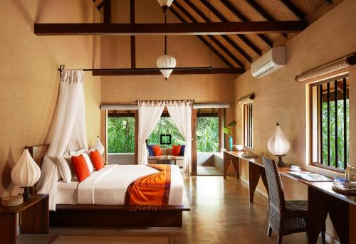 een slaapkamer met een bed en een bureau bij Jetwing Vil Uyana in Sigiriya