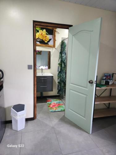 eine offene Tür zu einem Badezimmer mit Waschbecken in der Unterkunft Fare anuhe in Bora Bora