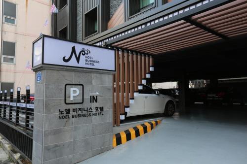a white car is parked under a parking garage at Noel Business Hotel in Busan