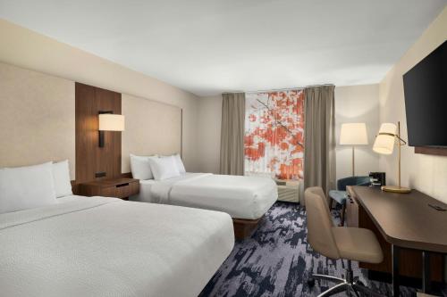 a hotel room with two beds and a desk at Fairfield Inn & Suites Indianapolis Airport in Indianapolis