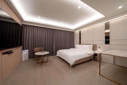 a hotel room with a bed and a table at 르벤토 호텔 in Jūrin-ri