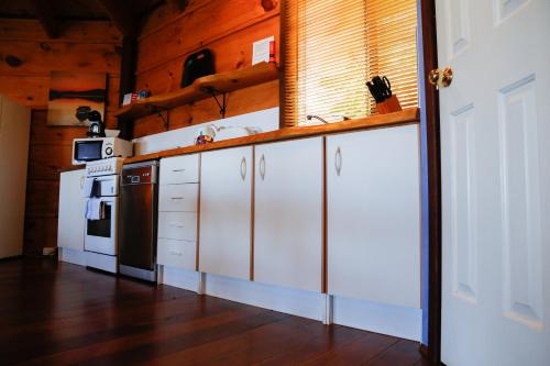 a kitchen with white cabinets and a stove top oven at Pelicans at Denmark in Denmark