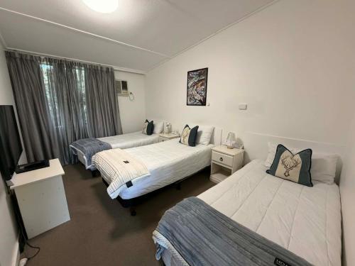 a bedroom with two beds and a television in it at Motel Bombala in Bombala