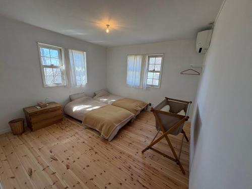 a bedroom with a bed and a wooden floor at papan room in Miyota