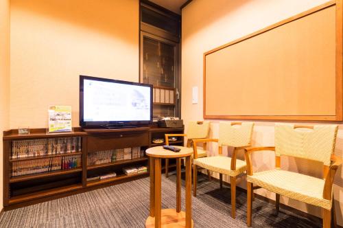 a classroom with a large screen and a board at Dormy Inn Premium Wakayama Natural Hot Spring in Wakayama