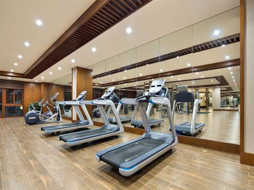 a gym with several treadmills and elliptical machines at Wyndham Grand Plaza Royale Wenchang in Wenchang