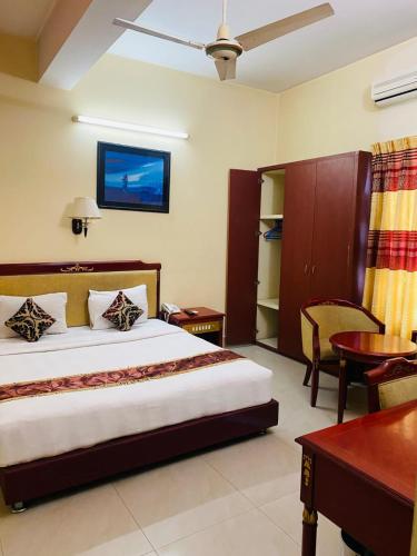 a bedroom with a bed and a table and a desk at Hotel Metro International in Sylhet