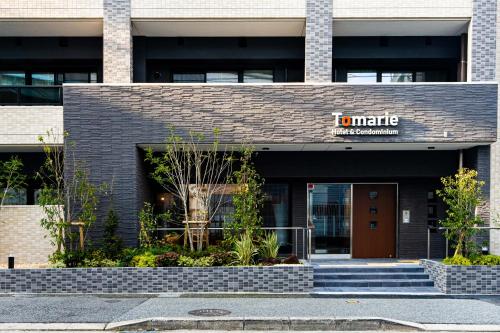 a front view of a building with a sign on it at Tomariehotel & condominium in Fukuoka