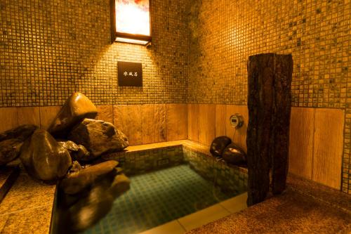 a pool of water in a bathroom with a window at Dormy Inn Premium Wakayama Natural Hot Spring in Wakayama