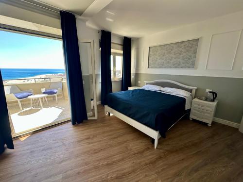 a bedroom with a bed and a view of the ocean at Blu Opèra Guest Rooms in Soverato Marina