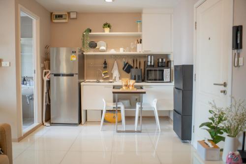 a kitchen with a refrigerator and a table and chairs at FavStay Ramkhamhaeng, Stylish 1BR Bangkok in Bangkok