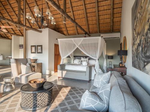 a living room with a bed and a couch at Lions Valley Lodge in Nambiti Game Reserve