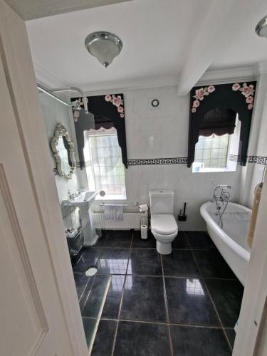 a bathroom with a tub and a toilet and a sink at Annasrose cottage in Middlesbrough