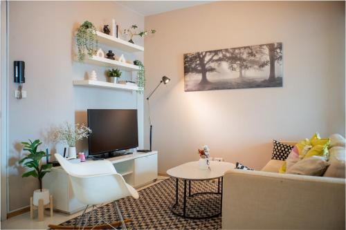 a living room with a couch and a tv at FavStay Ramkhamhaeng, Stylish 1BR Bangkok in Bangkok