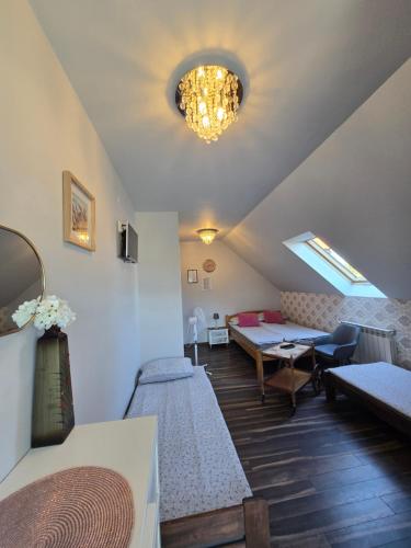 a room with two beds and a table in it at Cicha Dolina in Wydminy