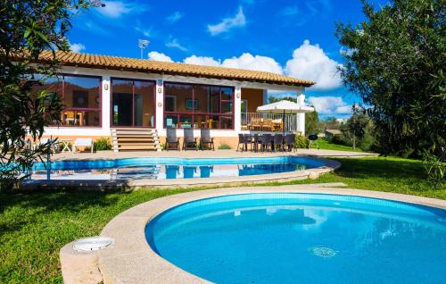 a villa with a swimming pool in front of a house at Sa Font Den Ros in Son Servera