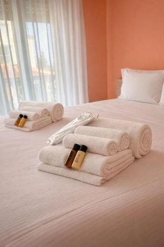 a pile of towels and bottles of wine sitting on a bed at Hotel Villa Trieste in Sirmione