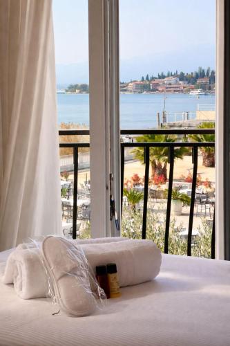 a bedroom with a bed with a view of a beach at Hotel Villa Trieste in Sirmione