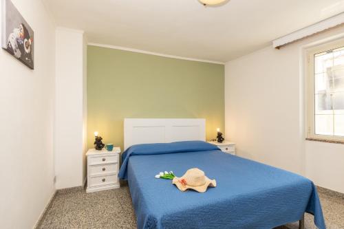 a bedroom with a blue bed with a hat on it at Appartamento La terrazza in Baunei