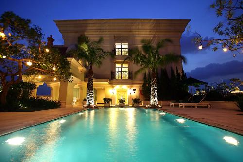 a swimming pool in front of a house at night at Hotel Gran Mahakam in Jakarta