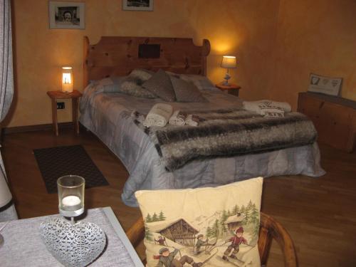 sypialnia z łóżkiem i stołem z kieliszkiem wina w obiekcie Maison Besenval w Aoście