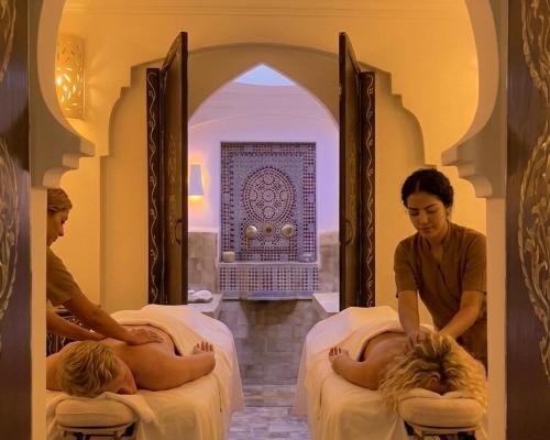 two women sitting on beds in a room at Hotel Al Alba Hammam & Restaurant in Asilah