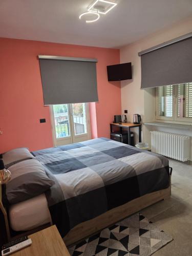a bedroom with a bed with red walls and windows at B&B Da Cavalot in Envie