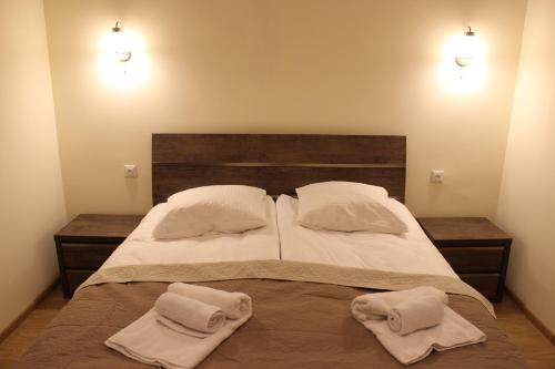 una camera da letto con un letto con due asciugamani sopra di Yango Apartment a Tbilisi City