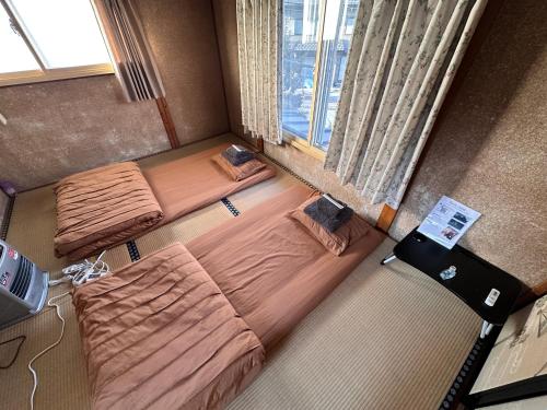 a room with two beds and a window at 世界遺産平泉の一軒家ステイ 国際シェアハウス in Hiraizumi