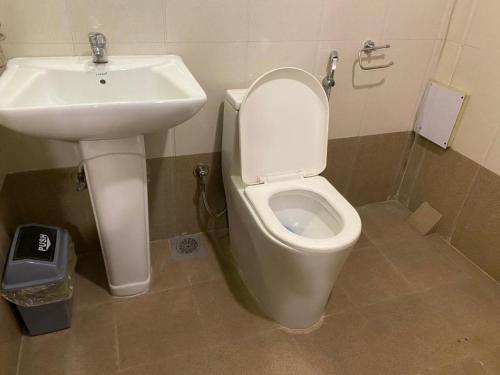 a bathroom with a white toilet and a sink at Hotel Malla Inn in Bhaktapur