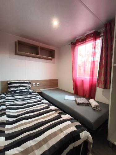 a small bedroom with a bed and a window at Eucalyptus 24 du samedi au samedi location in Valras-Plage
