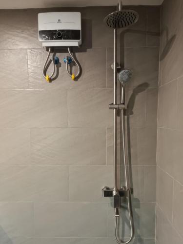 a bathroom with a shower with a shower head and a camera at Top Star Hotel Manaoag in Manaoag