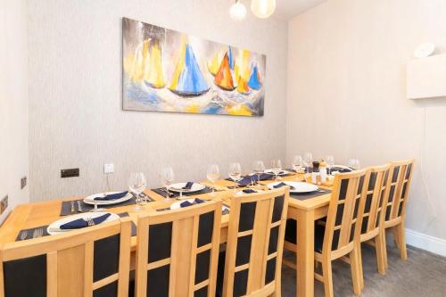 a dining room with a table with chairs and a painting at Clevelands Country House in Wroxall