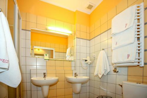 La salle de bains est pourvue de 2 lavabos et de toilettes. dans l'établissement Zajazd Partynia, à Partynia