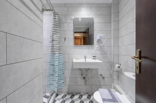 a bathroom with a sink and a toilet and a mirror at Mironi & Victoria in Limenas