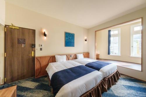 a bedroom with two large beds in a room at T9 Hakodate in Hakodate