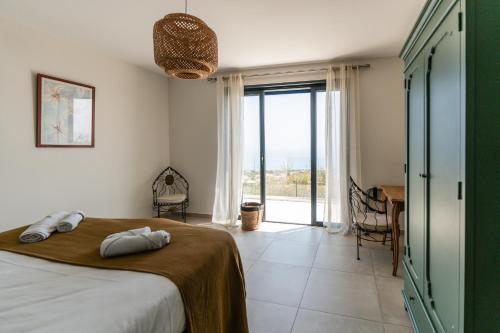 a bedroom with a bed and a view of the ocean at villa mare d'argentu - vue mer panoramique in Sari Solenzara