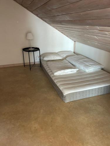 a bed in a white room with a side table at Sommartornsgård in Munkedal